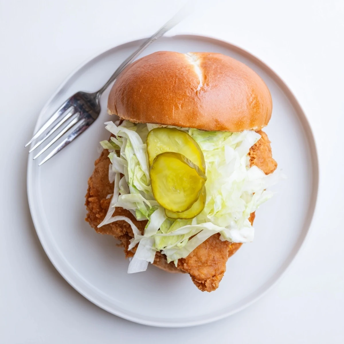 Golden brown crispy dill chicken sandwich stacked on toasted brioche bun with lettuce