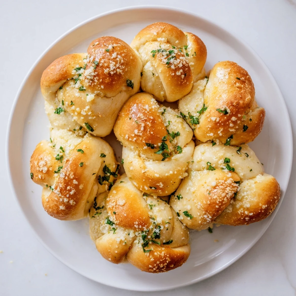 Warm gluten-free garlic knots brushed with melted garlic butter and herbs on a rustic wooden board