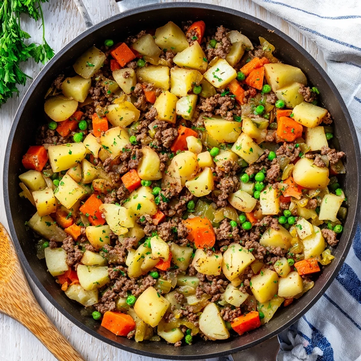 Golden brown one pan ground beef and potatoes skillet loaded with colorful vegetables and fresh parsley garnish