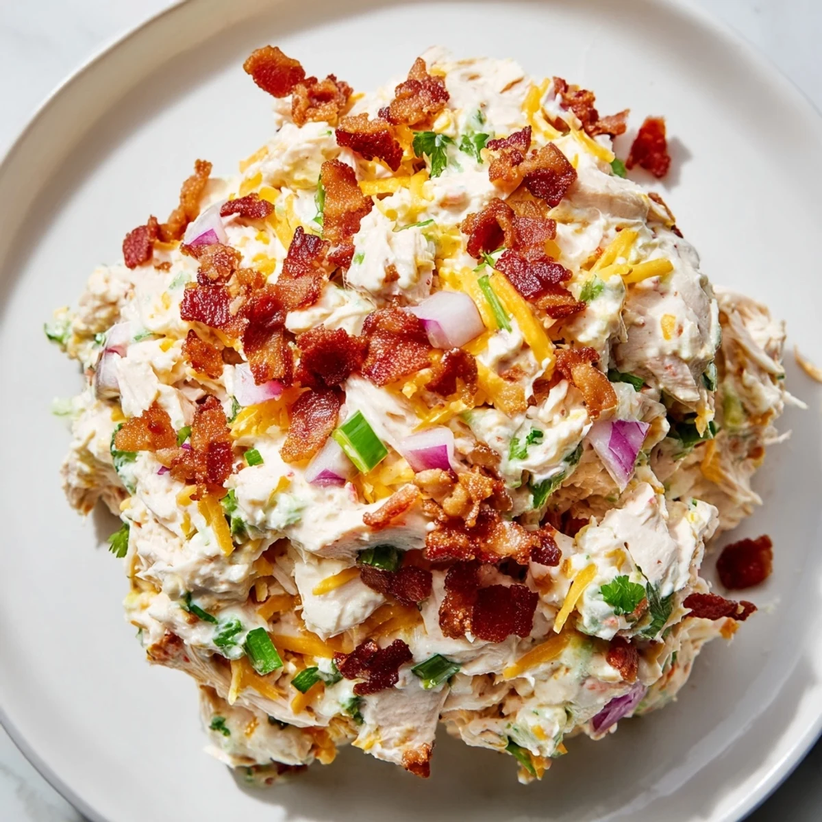 Creamy jalapeno popper keto chicken salad topped with crispy bacon crumbles and fresh green onions