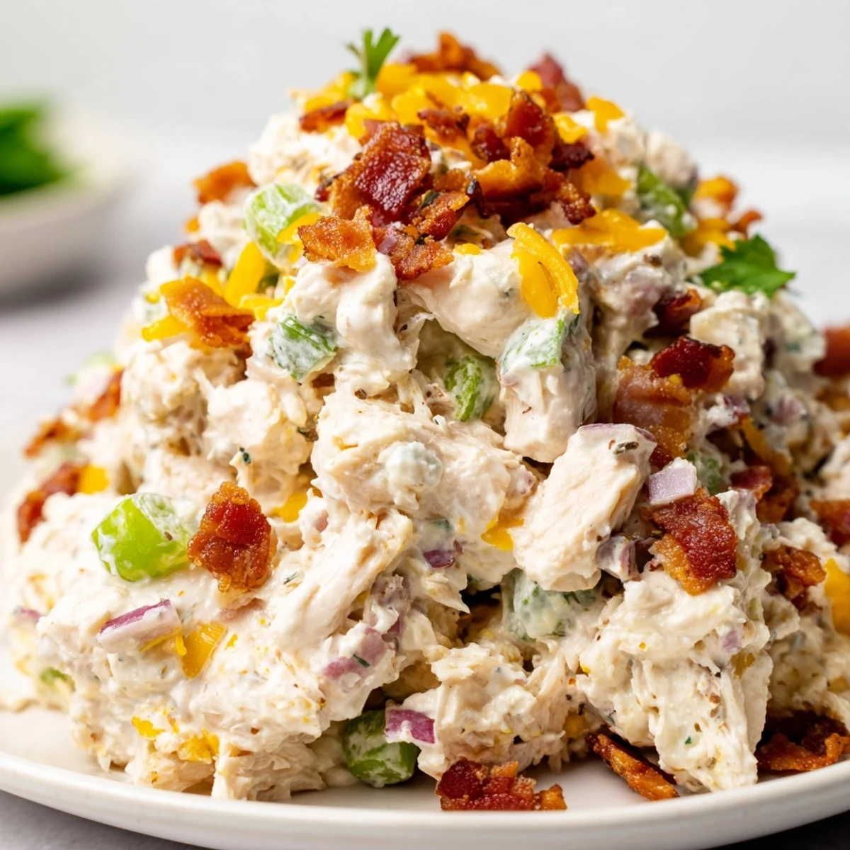 Spicy low-carb chicken salad with diced jalapenos, cheddar cheese, and smoky bacon in a white bowl