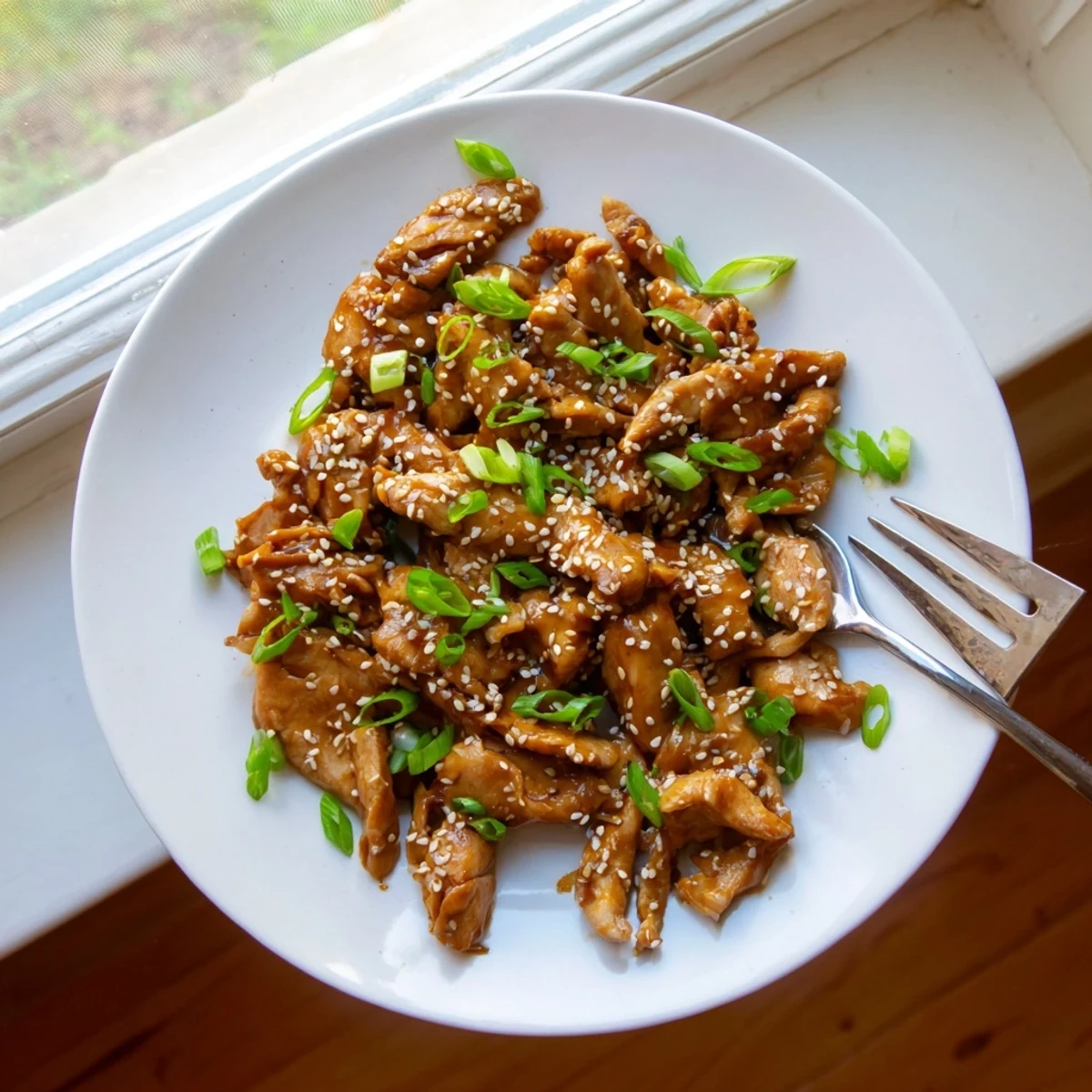 Golden brown chicken thighs coated in sweet homemade teriyaki sauce after slow cooking