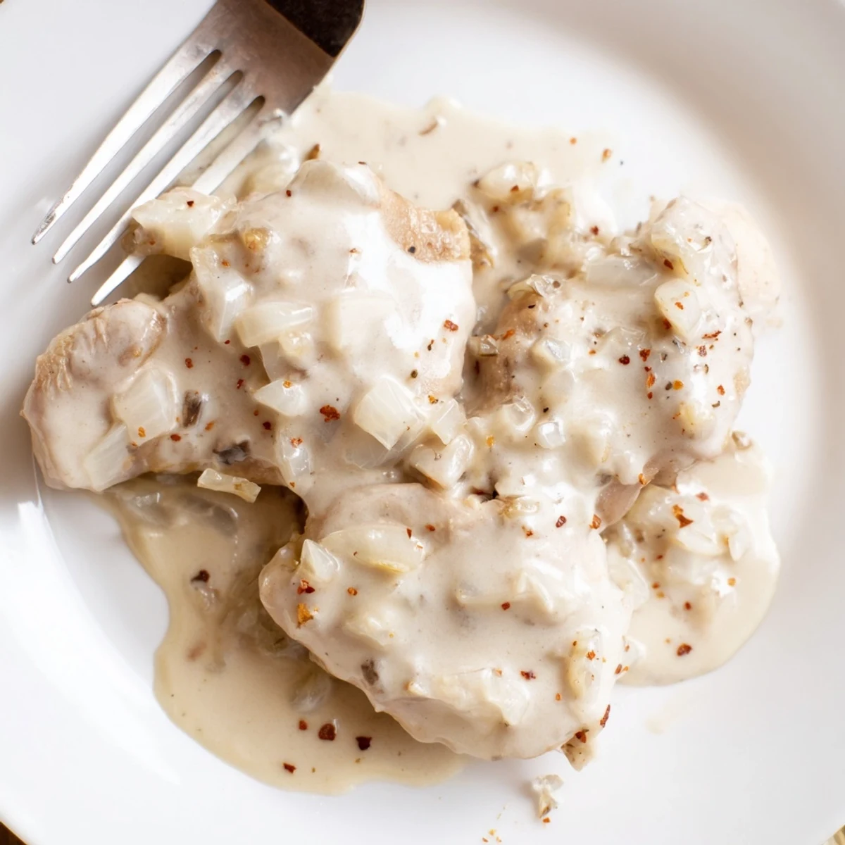 Creamy crockpot chicken thighs served with thick savory gravy over tender meat pieces
