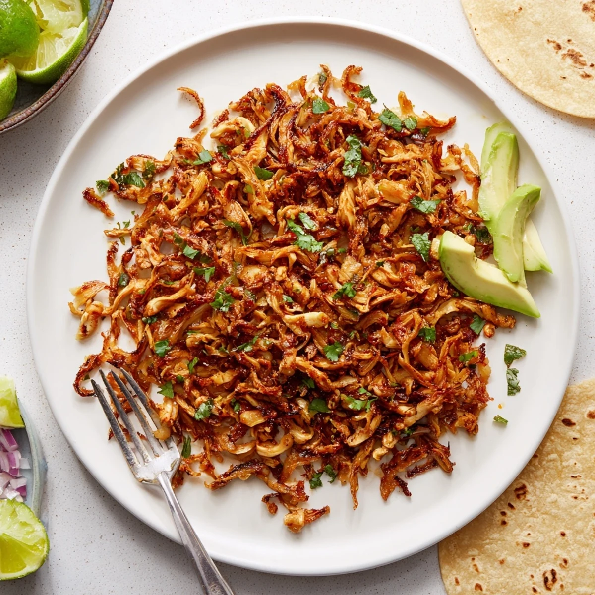Golden brown vegan carnitas made with shredded mushrooms spiced with cumin and smoked paprika in a serving bowl