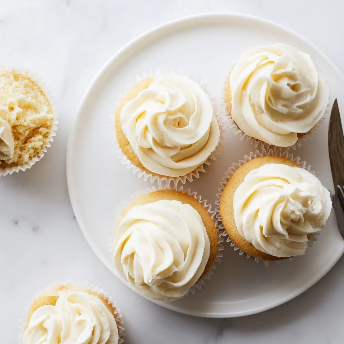 Homemade vanilla cupcakes with smooth white frosting decorated with colorful sprinkles for celebrations