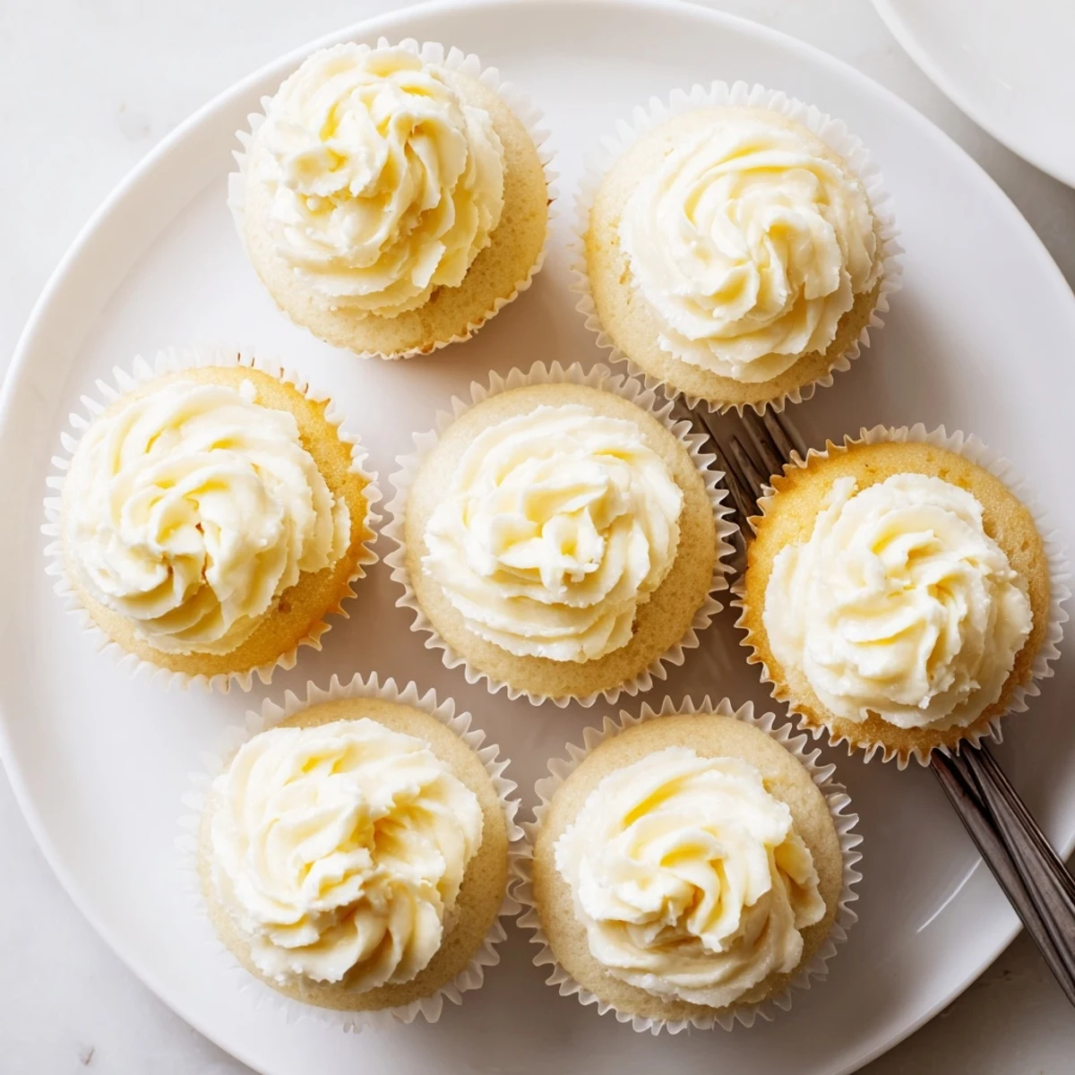 Light and fluffy vanilla cupcakes piped with creamy swirls of vanilla buttercream frosting