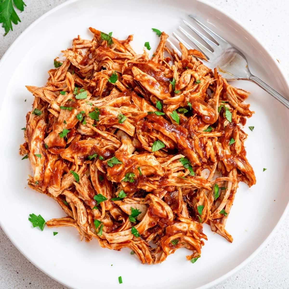 Savory Sweet Baby Ray's Crockpot Chicken shredded and coated in glossy, tangy-sweet smoky sauce