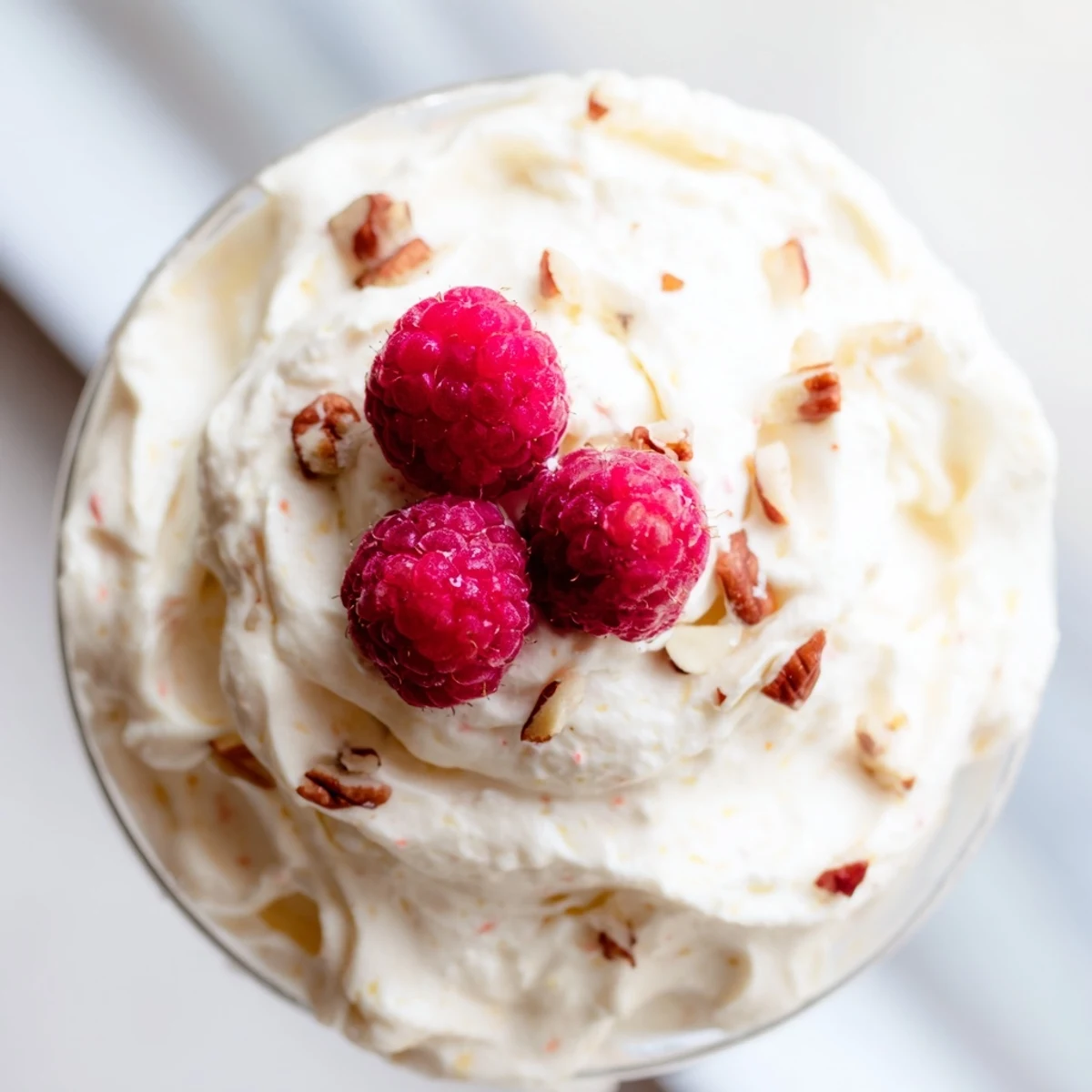 Creamy keto cheesecake fluff spooned into glasses topped with fresh red berries