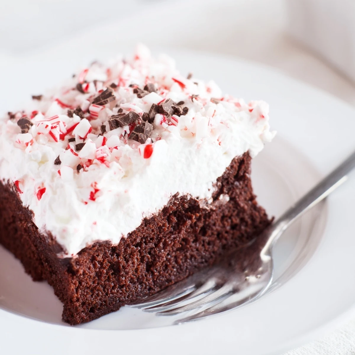 Sliced Peppermint Poke Cake showing pudding filling studded with crushed peppermint