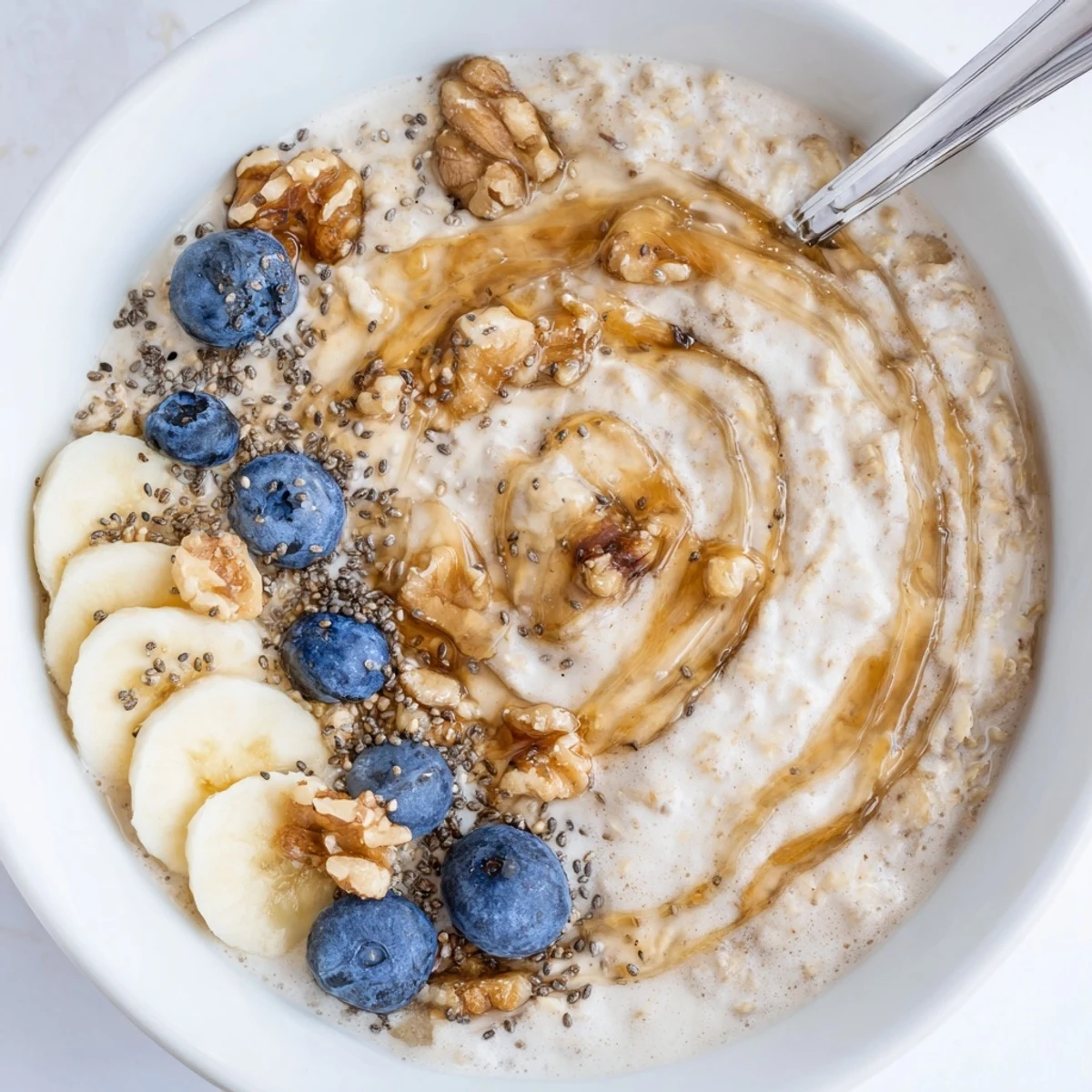 Creamy Protein Oatmeal steaming in bowl topped with banana and berries