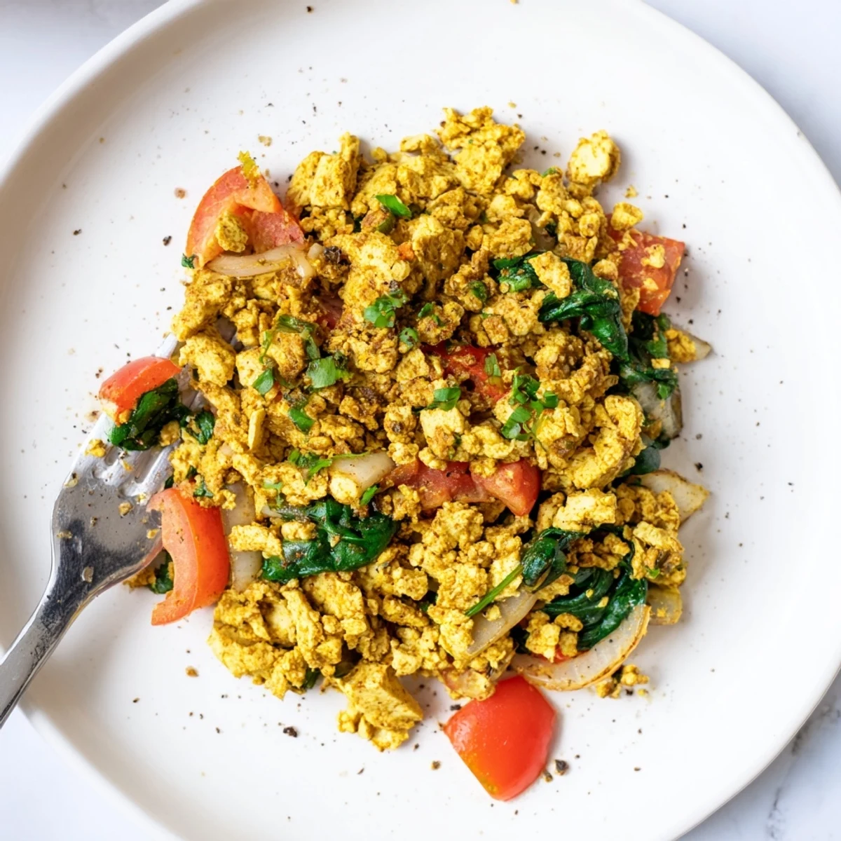 Hearty Tofu Scramble piled on toast with creamy avocado slices