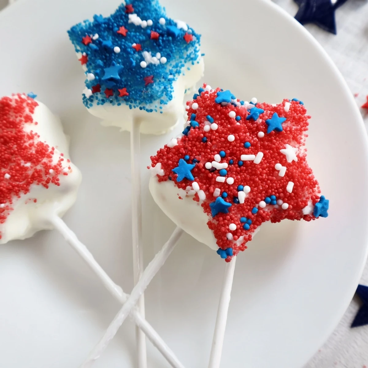 Fourth Of July Star Cheesecake Pops arranged on a platter, dipped in chocolate
