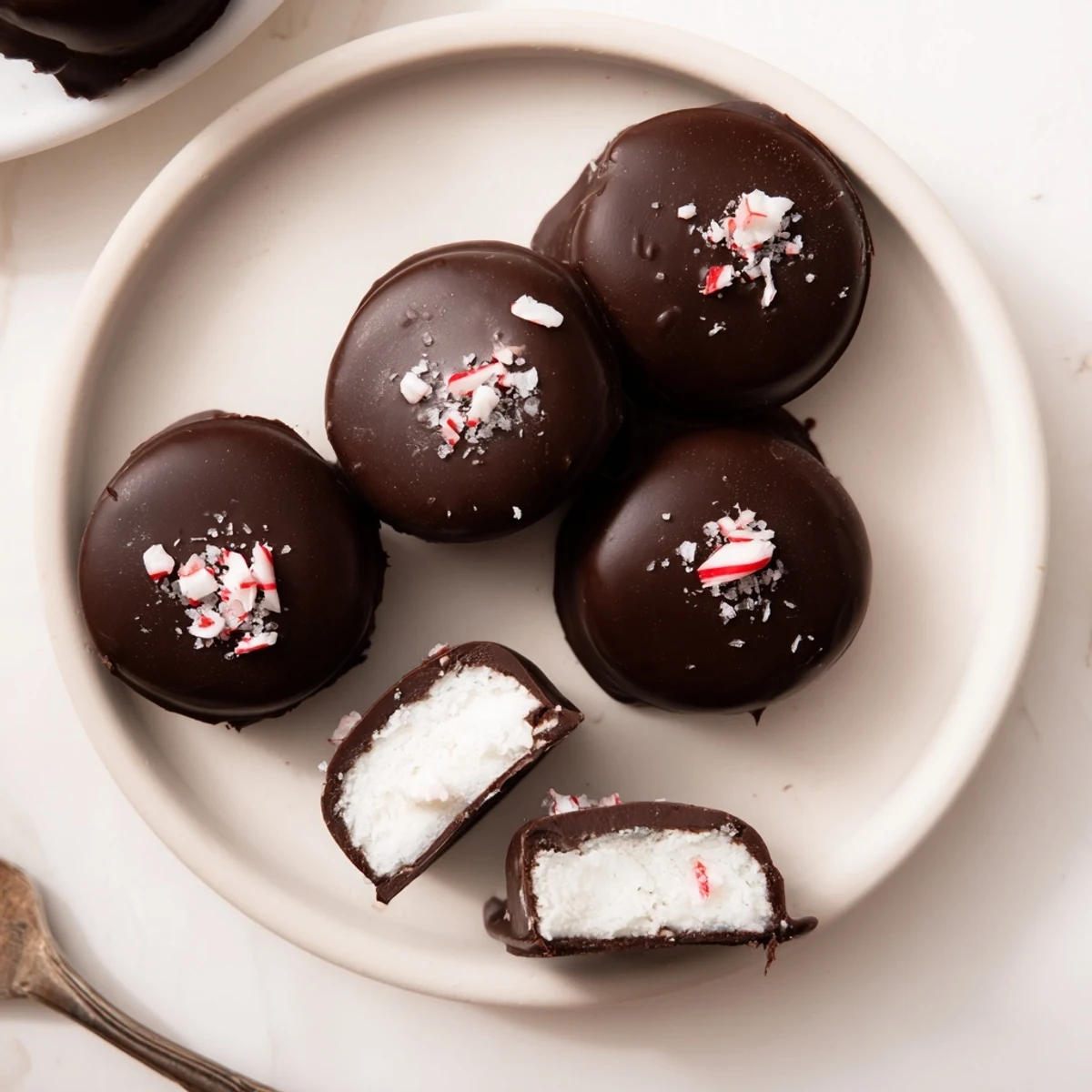 Peppermint Patties glistening in dark chocolate, dusted with crushed candy.
