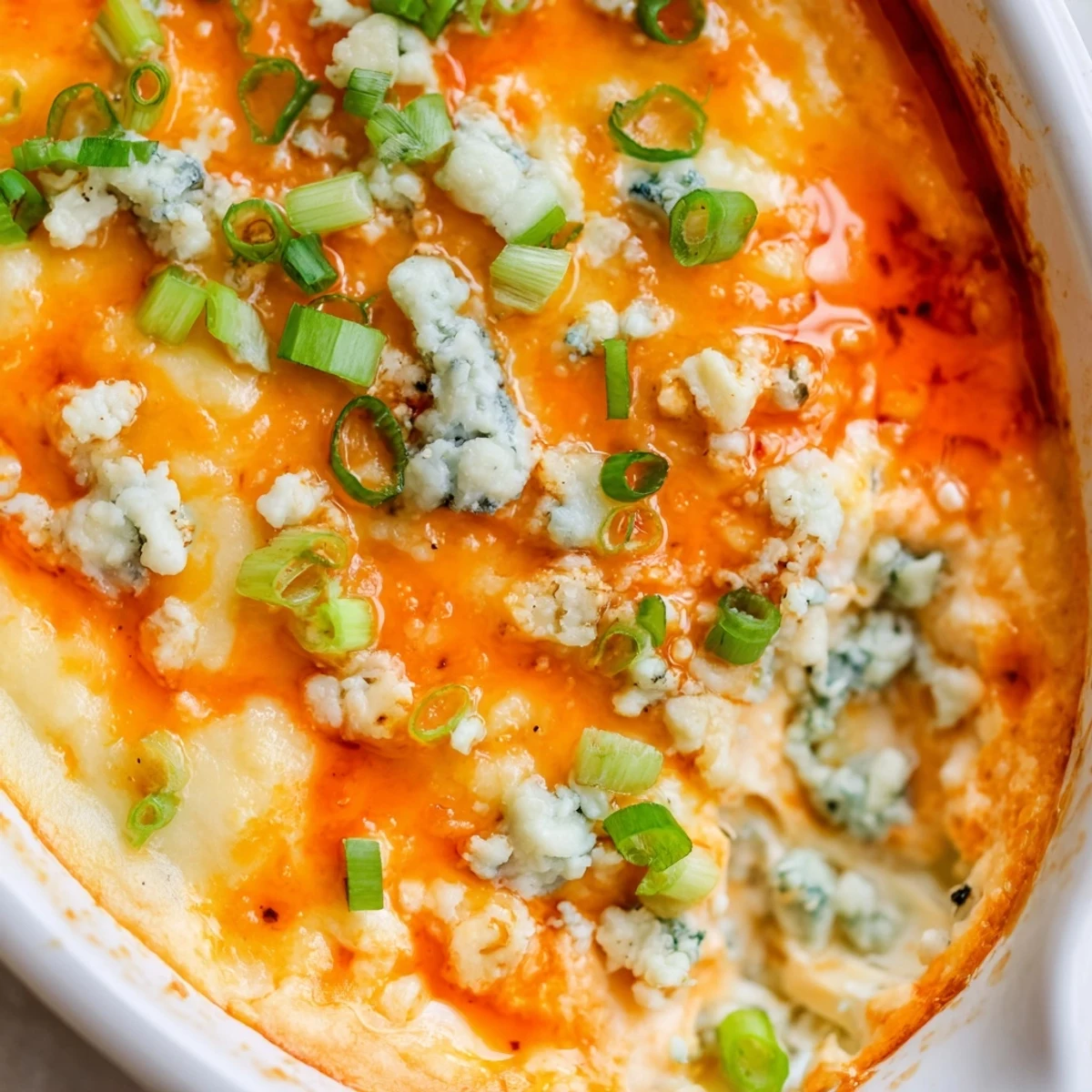 Creamy white bean buffalo dip topped with green onions served with crispy tortilla chips