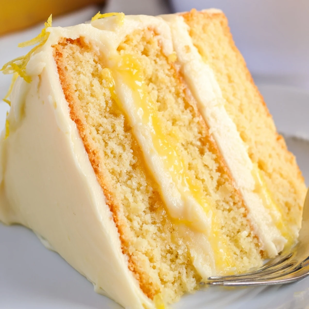 Golden lemon layer cake with fluffy white buttercream and tart lemon curd filling