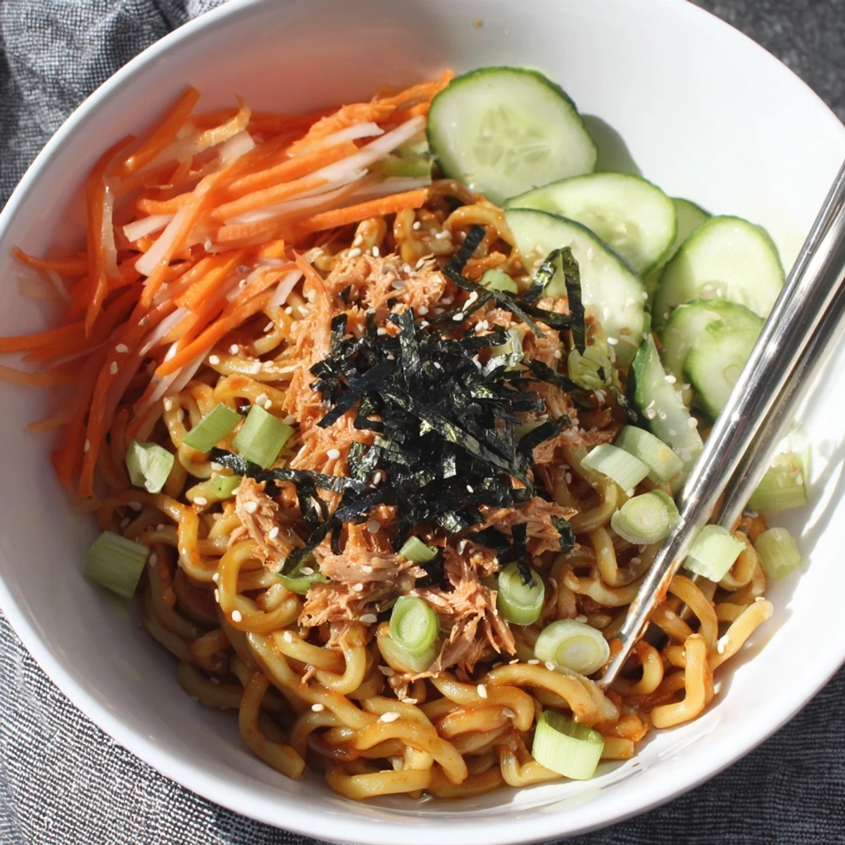 Spicy tuna udon noodles tossed in creamy sriracha sauce with fresh julienned carrots and cucumbers