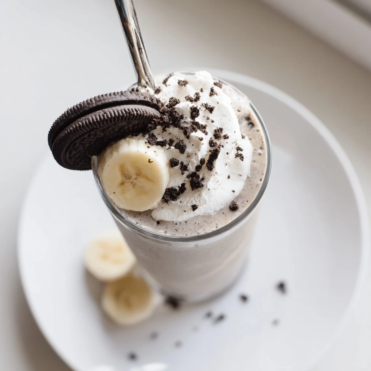 Cookies And Cream Protein Shake poured into glass with creamy cookie crumbs topping
