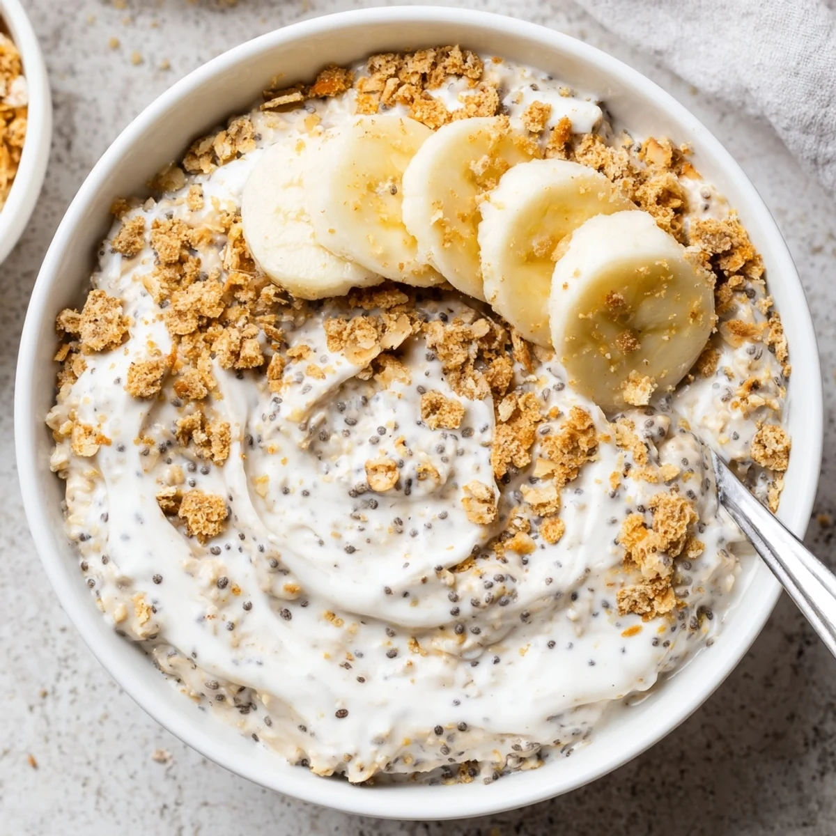 Jar of Coconut Cream Pie Overnight Oats garnished with crushed graham crackers