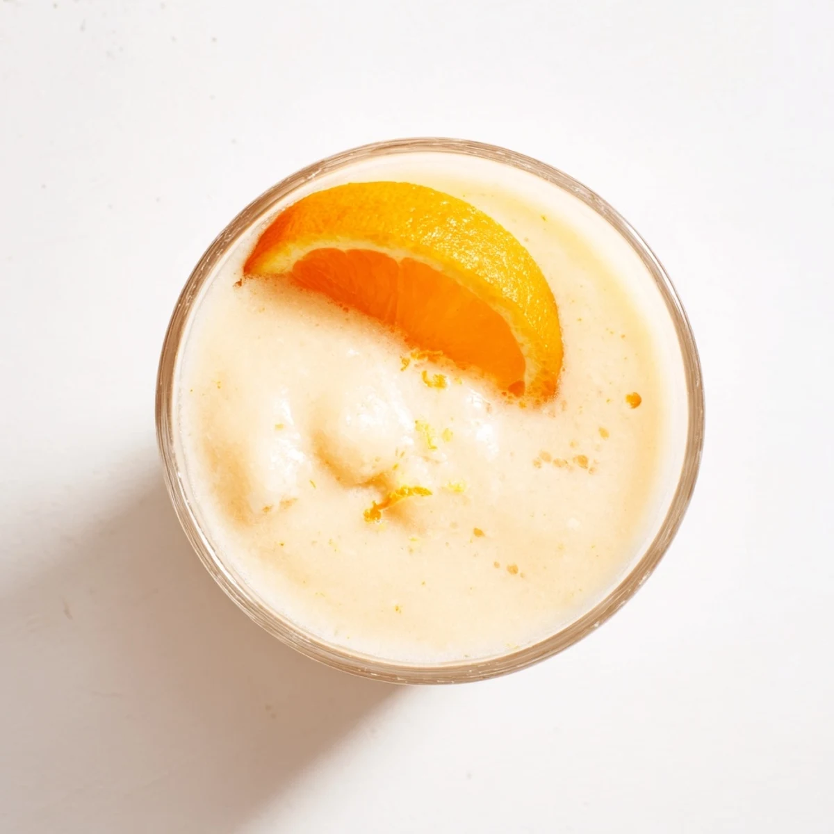 Thick orange cream slush topped with mint sprig in a chilled glass showcasing icy texture