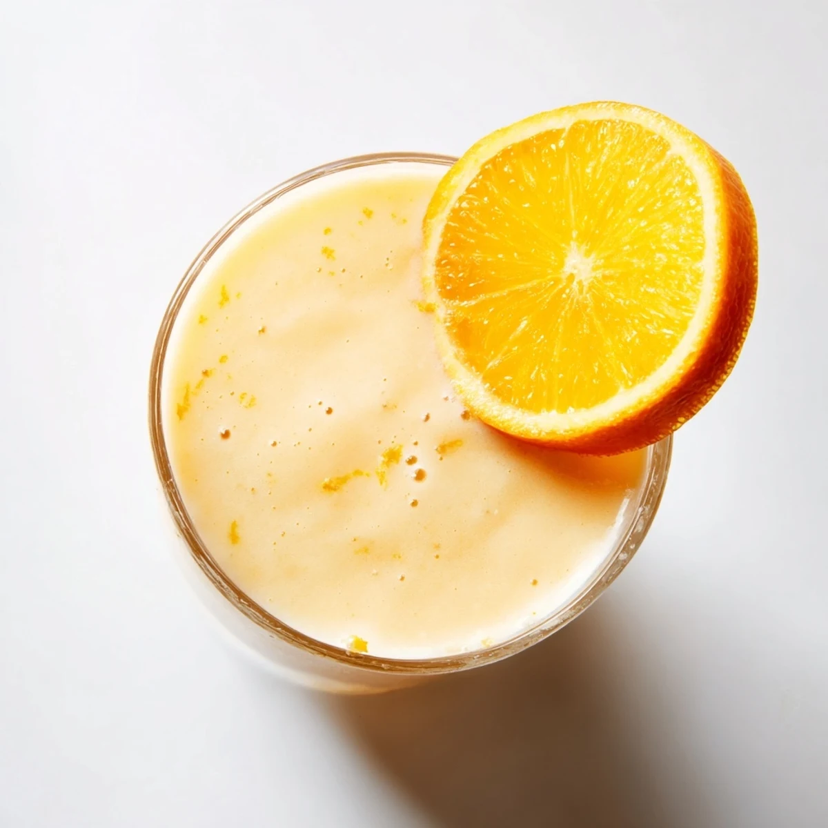 Close-up of frozen orange cream slush with visible ice crystals and whipped cream swirl topping