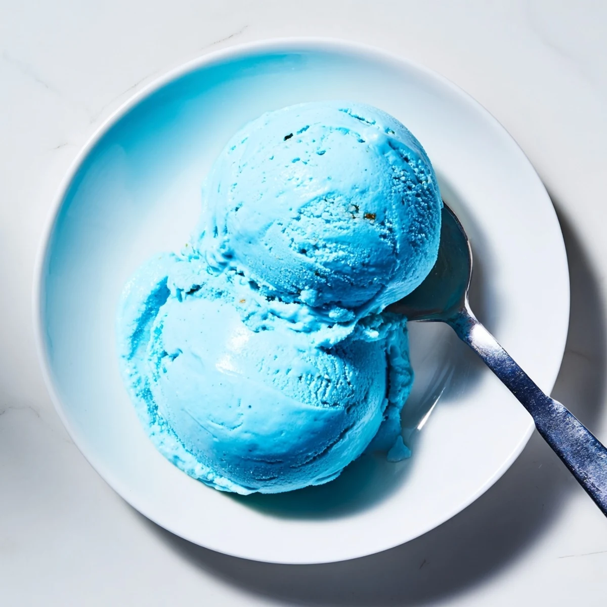 Creamy blue moon ice cream scooped into a crispy waffle cone with sprinkles