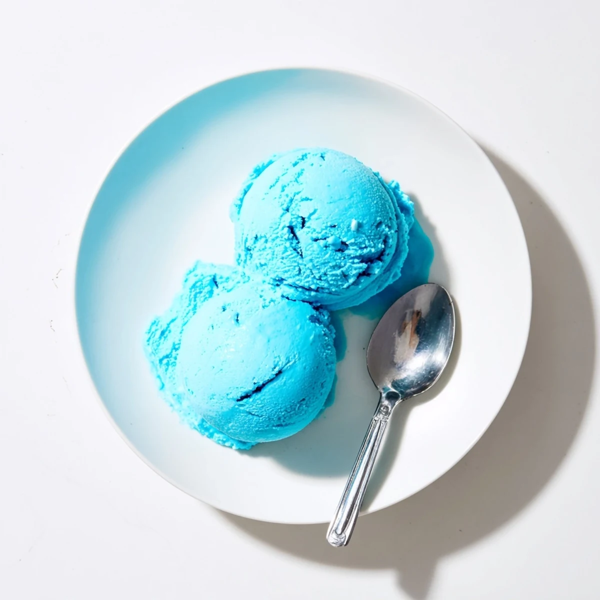 Vibrant blue moon ice cream served in a bowl topped with whipped cream