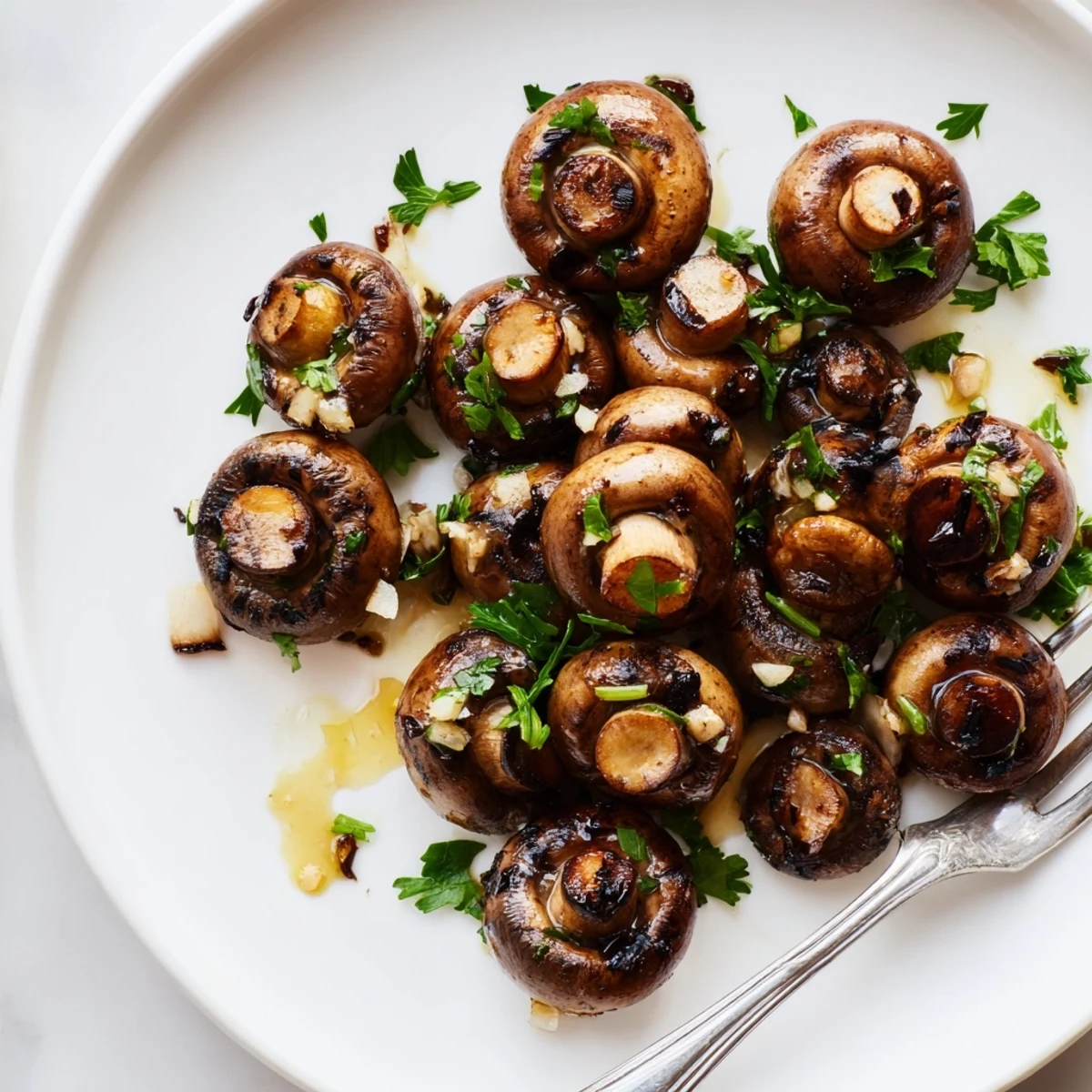 Golden sautéed grilled garlic mushrooms glistening with butter and fresh parsley