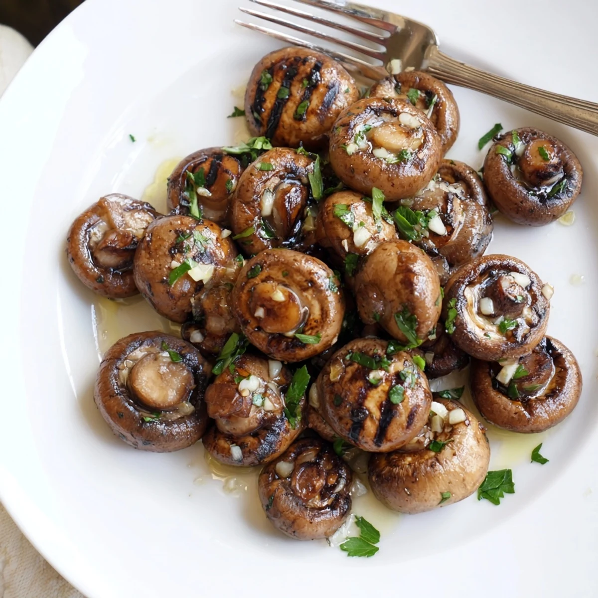 Smoky grilled garlic mushrooms sizzling in a skillet with aromatic herbs