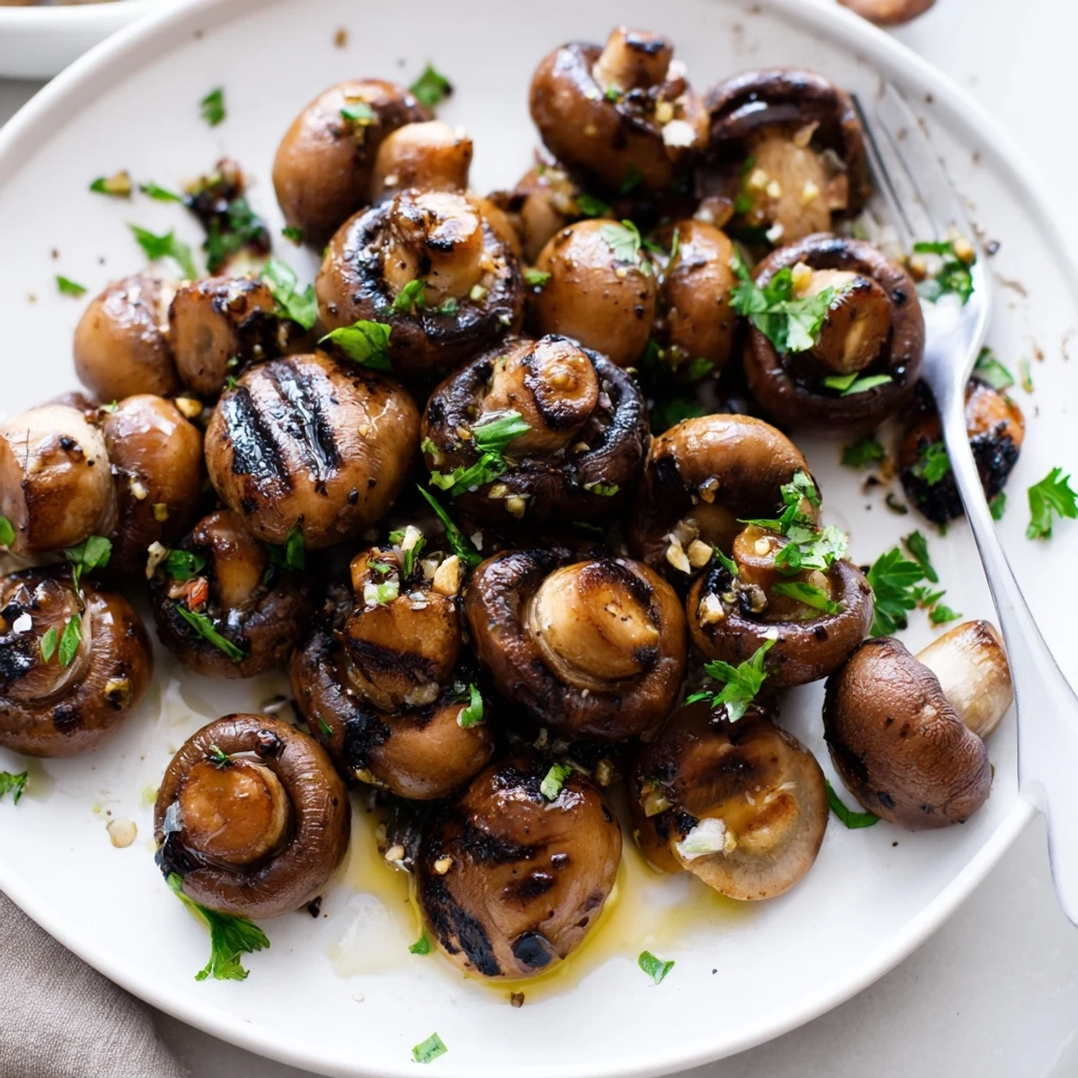 Tender charred mushrooms coated in garlic butter served with bright lemon wedges