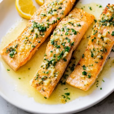 Crispy garlic butter salmon drizzled with rich sauce and garnished with fresh parsley
